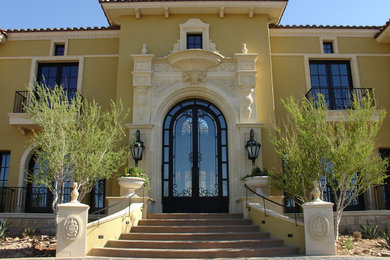 Example of a large ornate yellow two-story stucco exterior home design in Phoenix with a hip roof