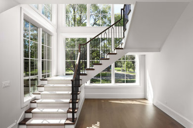 Example of a huge transitional wooden floating wood railing staircase design in Chicago with wooden risers