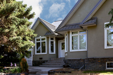 Inspiration for a mid-sized brown one-story stucco gable roof remodel in Calgary
