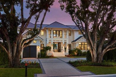 Inspiration for an expansive transitional two-storey stucco white house exterior in Miami with a metal roof and a hip roof.