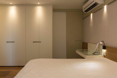 Modelo de dormitorio de tamaño medio con suelo de madera en tonos medios y papel pintado