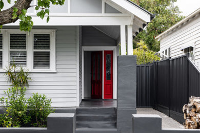 Mid-sized contemporary one-storey white house exterior in Melbourne with wood siding.