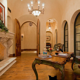 Design ideas for an expansive modern study in Phoenix with brown walls, dark hardwood flooring, a two-sided fireplace, a stone fireplace surround, a freestanding desk and brown floors.