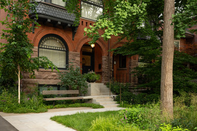 Photo of a small contemporary partial sun front yard stone and wood fence landscaping in Toronto for spring.