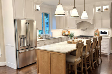 Inspiration for a large transitional medium tone wood floor and brown floor kitchen pantry remodel in Boston with recessed-panel cabinets, white cabinets, quartzite countertops, ceramic backsplash, stainless steel appliances, an island and beige countertops