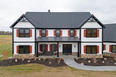 Example of a large white two-story vinyl and board and batten house exterior design in Other with a mixed material roof and a black roof