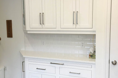 Eat-in kitchen - mid-sized traditional u-shaped dark wood floor and brown floor eat-in kitchen idea in Other with an undermount sink, recessed-panel cabinets, white cabinets, quartzite countertops, white backsplash, subway tile backsplash, white appliances, a peninsula and white countertops