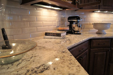 Example of a large classic u-shaped open concept kitchen design in Other with dark wood cabinets, granite countertops, white backsplash, stainless steel appliances and an island
