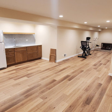 Fully remodeled 1970s finished basement with luxury vinyl plank flooring and can