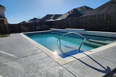Example of a mid-sized minimalist backyard rectangular lap pool design in Dallas with decking