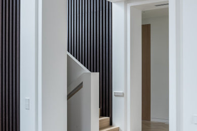 Immagine di un soggiorno design con sala formale, pareti bianche, pavimento in legno massello medio, pavimento marrone, soffitto ribassato e pannellatura