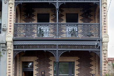 Large traditional three-storey brick brown exterior in Melbourne.