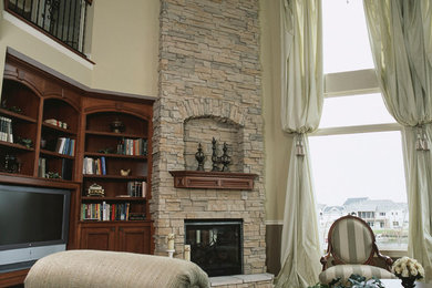 Large elegant enclosed dark wood floor family room photo in Minneapolis with beige walls, a standard fireplace, a stone fireplace and a media wall