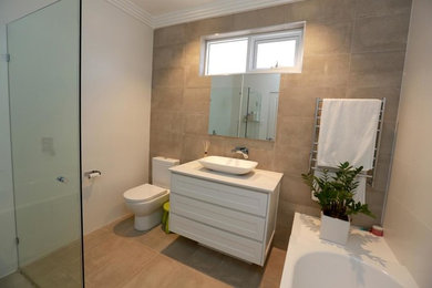 Design ideas for a mid-sized transitional bathroom in Sydney with a vessel sink, beige tile, recessed-panel cabinets, white cabinets and beige walls.