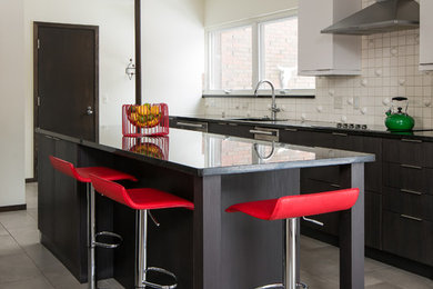 Eat-in kitchen - mid-sized modern ceramic tile eat-in kitchen idea in Detroit with an undermount sink, flat-panel cabinets, white cabinets, granite countertops, white backsplash, ceramic backsplash, stainless steel appliances and an island