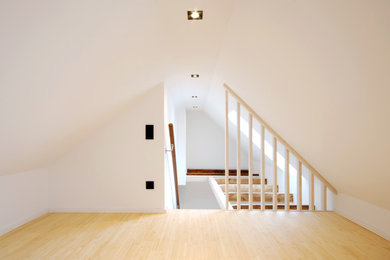Ejemplo de habitación infantil unisex de 4 a 10 años minimalista de tamaño medio con paredes blancas, suelo de madera clara y suelo beige