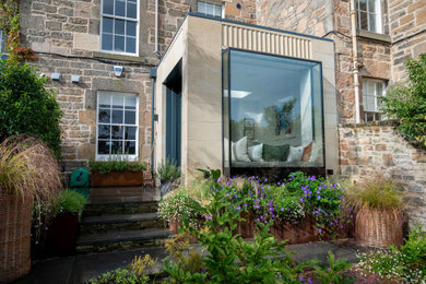 Inspiration for a large contemporary four-story stone flat roof remodel in Edinburgh with a green roof