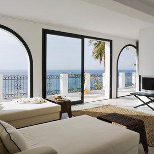 Imagen de salón abierto, mediterráneo, grande, con paredes blancas y pared multimedia