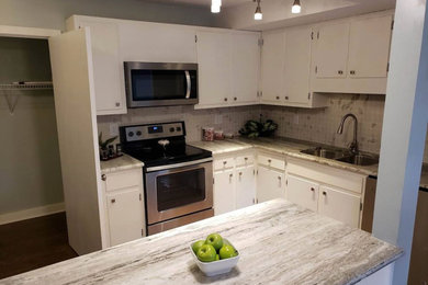 Mid-sized transitional u-shaped medium tone wood floor and brown floor eat-in kitchen photo in Raleigh with an undermount sink, shaker cabinets, white cabinets, granite countertops, multicolored backsplash, ceramic backsplash, stainless steel appliances, an island and multicolored countertops