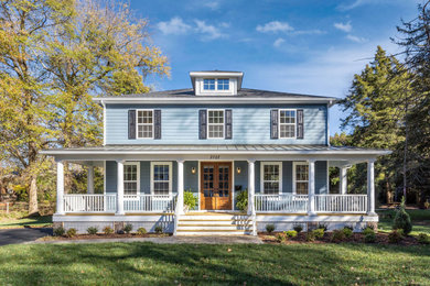 Example of a mid-sized classic blue two-story wood and clapboard exterior home design in Richmond with a mixed material roof and a black roof