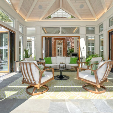 Cabana lounge seating with folding glass doors open to patio and brick fireplace