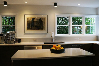 Enclosed kitchen - mid-sized contemporary u-shaped porcelain tile and gray floor enclosed kitchen idea in Seattle with a double-bowl sink, flat-panel cabinets, brown cabinets, quartz countertops, beige backsplash, stainless steel appliances, an island and beige countertops