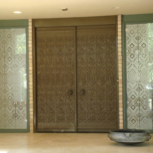 Eklektisk inredning av en stor ingång och ytterdörr, med gröna väggar, travertin golv, en dubbeldörr och en brun dörr