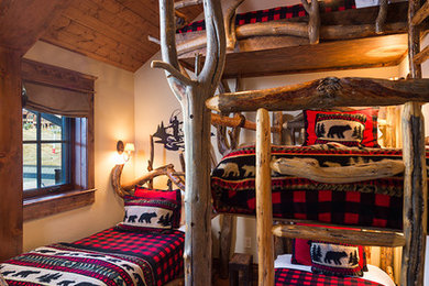 Inspiration for a mid-sized rustic guest medium tone wood floor bedroom remodel in Other with beige walls