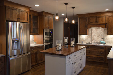 Example of a dark wood floor and brown floor enclosed kitchen design in Raleigh with dark wood cabinets, granite countertops, beige backsplash, travertine backsplash and an island
