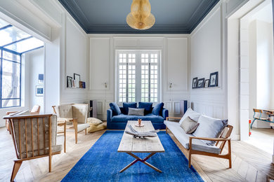 Aménagement d'un grand salon classique fermé avec un mur blanc, un sol en bois brun, aucune cheminée et aucun téléviseur.