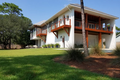 Large coastal white two-story stucco exterior home idea in Miami with a hip roof and a shingle roof