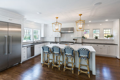 Inspiration for a mid-sized contemporary l-shaped dark wood floor open concept kitchen remodel in Cincinnati with an undermount sink, shaker cabinets, white cabinets, soapstone countertops, white backsplash, subway tile backsplash, stainless steel appliances and an island