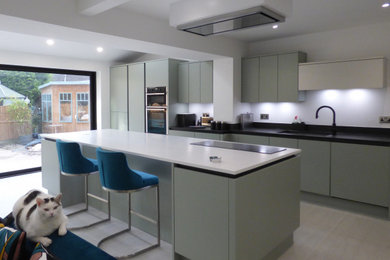 This is an example of a large contemporary single-wall kitchen/diner in Other with flat-panel cabinets, green cabinets, laminate countertops, an island and multicoloured worktops.