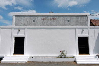Cette image montre un grand porche d'entrée de maison avant urbain avec une dalle de béton.