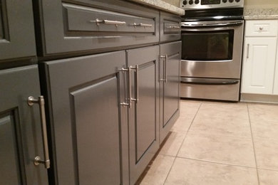 Eat-in kitchen - mid-sized traditional l-shaped travertine floor eat-in kitchen idea in Baltimore with an undermount sink, raised-panel cabinets, white cabinets, granite countertops, stainless steel appliances and an island