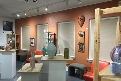 Home studio - mid-sized eclectic gray floor home studio idea in Houston with orange walls