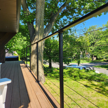 Deck with black metal post cable railing in Quebec, Canada