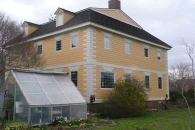 Inspiration for a mid-sized timeless yellow three-story concrete exterior home remodel in Other