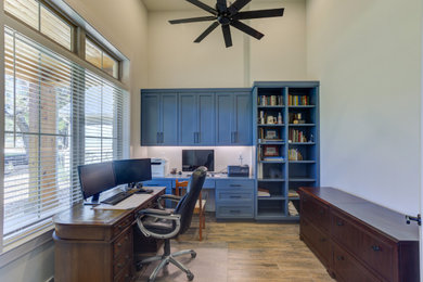 Inspiration for a mid-sized modern built-in desk porcelain tile and brown floor home office remodel in Austin with white walls, a standard fireplace and a stone fireplace