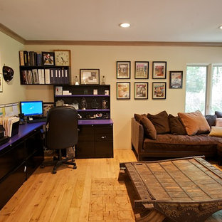 Design ideas for a large modern study in Philadelphia with beige walls, light hardwood flooring, a corner fireplace, a plastered fireplace surround and a freestanding desk.