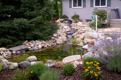 Design ideas for a large partial sun backyard water fountain landscape in Other.
