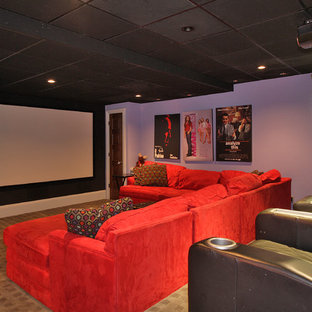 This is an example of a large eclectic enclosed home cinema in Newark with purple walls, carpet and a projector screen.