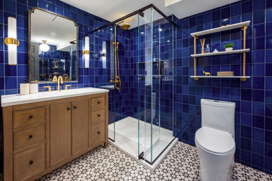 Bathroom - mid-sized master blue tile and ceramic tile porcelain tile, white floor and single-sink bathroom idea in Philadelphia with furniture-like cabinets, brown cabinets, a one-piece toilet, blue walls, an integrated sink, quartz countertops, a hinged shower door, white countertops, a niche and a freestanding vanity