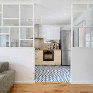Idéer för mellanstora minimalistiska linjära beige kök och matrum, med en nedsänkt diskho, släta luckor, skåp i ljust trä, träbänkskiva, beige stänkskydd, stänkskydd i trä, rostfria vitvaror, cementgolv och blått golv