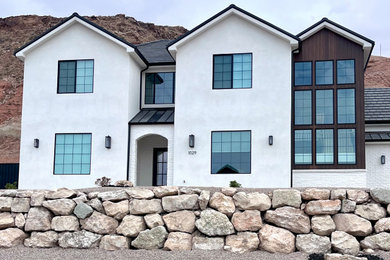 Transitional white two-story stucco exterior home photo in Salt Lake City with a tile roof and a black roof