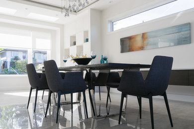 This is an example of a mid-sized contemporary open plan dining in Vancouver with white walls, no fireplace, porcelain floors and grey floor.