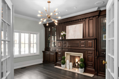 Aménagement d'un salon de taille moyenne et fermé avec parquet foncé, une cheminée standard, un manteau de cheminée en pierre et un sol marron.