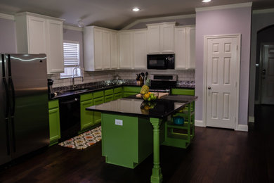 Large transitional l-shaped dark wood floor open concept kitchen photo in Dallas with an undermount sink, recessed-panel cabinets, green cabinets, granite countertops, metallic backsplash, stainless steel appliances and an island