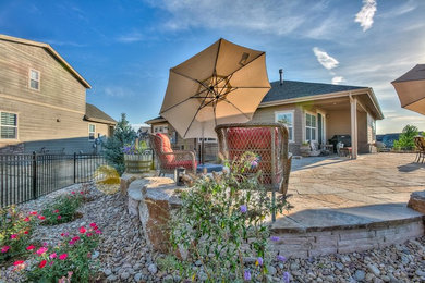 Design ideas for a large and desert look backyard partial sun xeriscape in Denver with natural stone pavers.