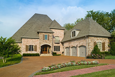 This is an example of a large traditional three-storey brick red exterior in Nashville with a gable roof.